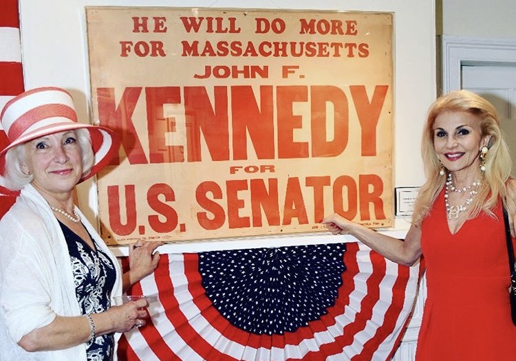 Pamela Wright with a John F. Kennedy banner