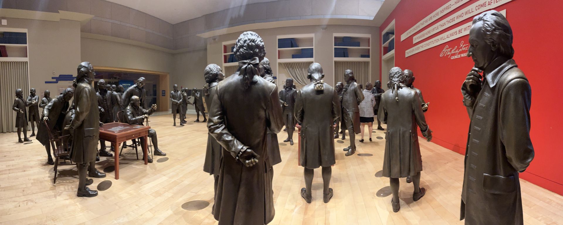 John Dickinson (right) stands off to the side among the statues of Signers at the National Constitution  Center. George Washington stands at the left before a table at which Benjamin Franklin sits. Photo by Edwin Grosvenor