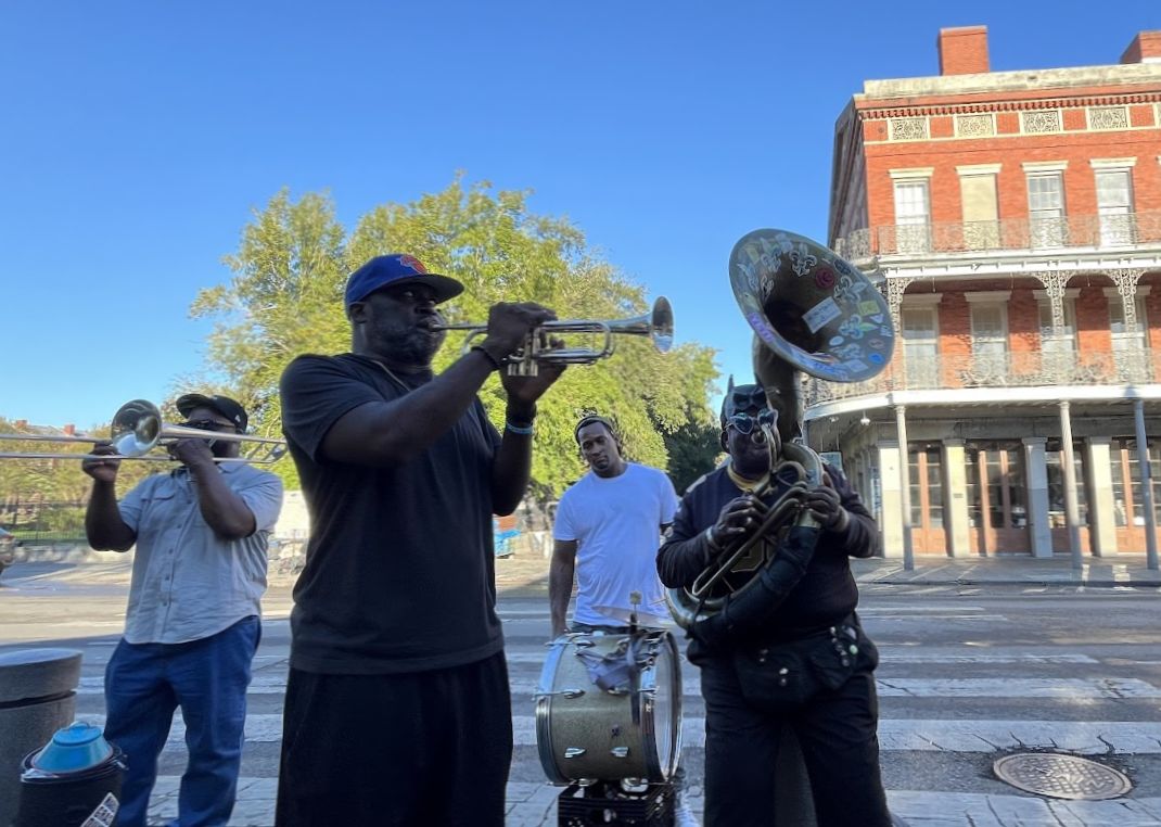 Street musicians play near Jackson Square for a bucket of dollar bills.